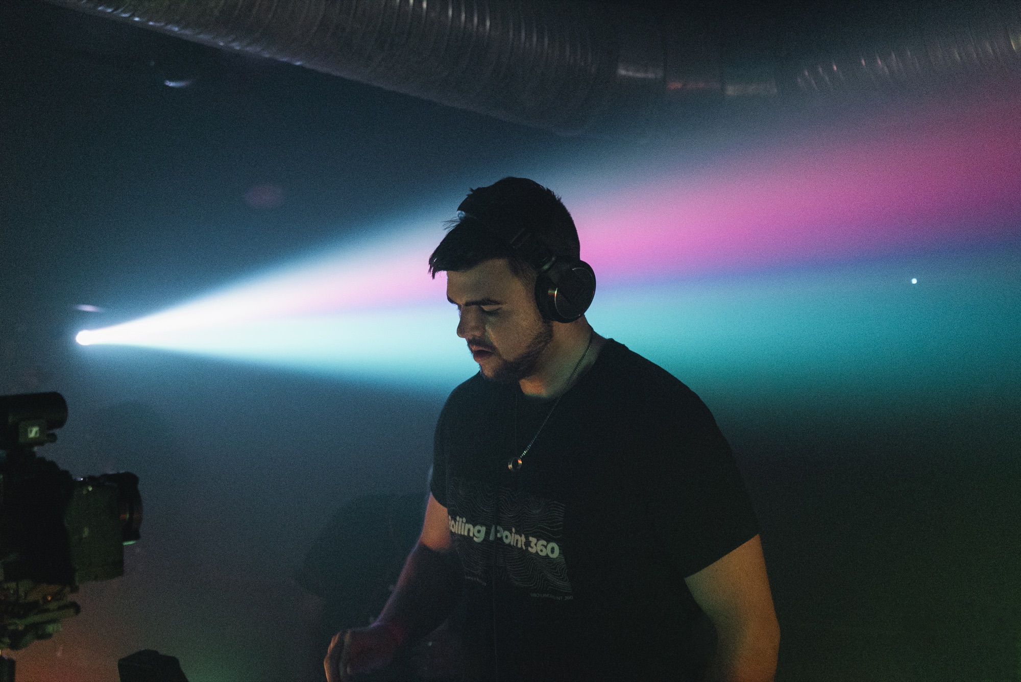 DJ performing under stage lighting at a YA DIG event