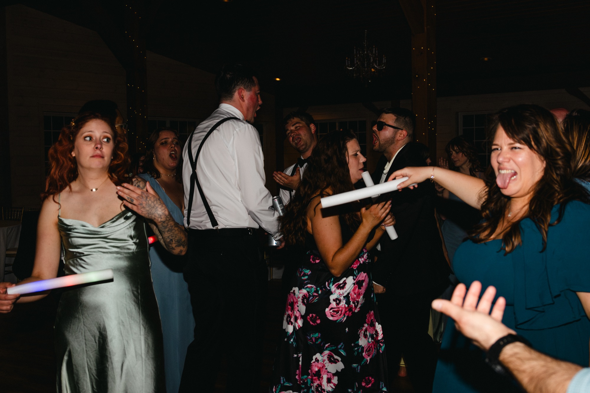 Guests dancing with glow sticks on a packed floor