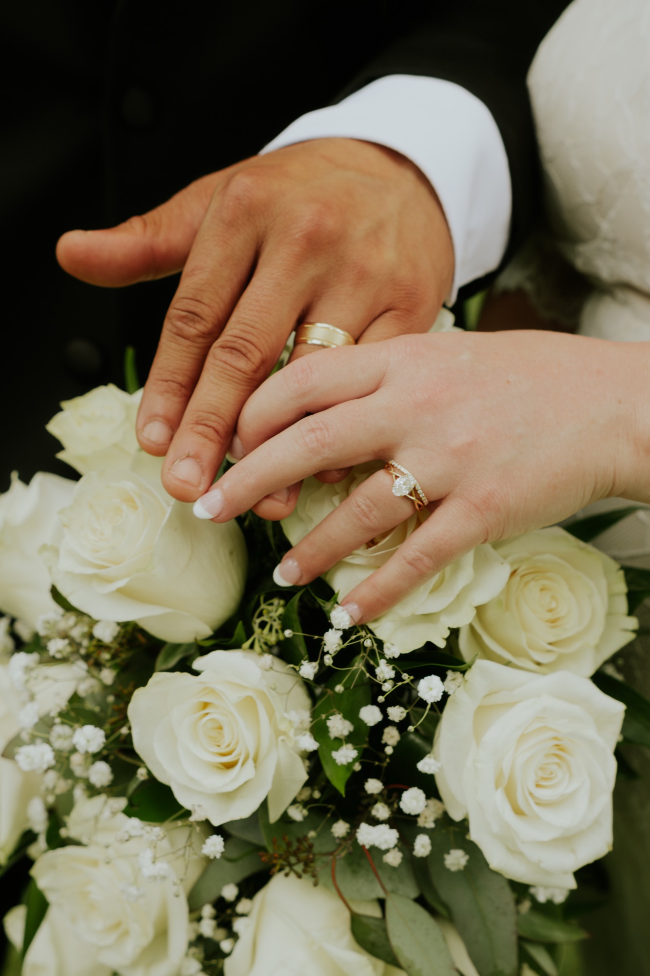 Wedding rings on a white rose bouquet